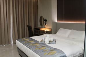 A hotel room with a neatly made bed, a desk with a lamp, and a large window with curtains. - Modern King Sky Standard Room (Parañaque)