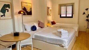 A hotel room with a bed, a round table with chairs, a lamp, and artwork on the walls. - Ky Dong Hotel by N Retreat (Ho Chi Minh City)