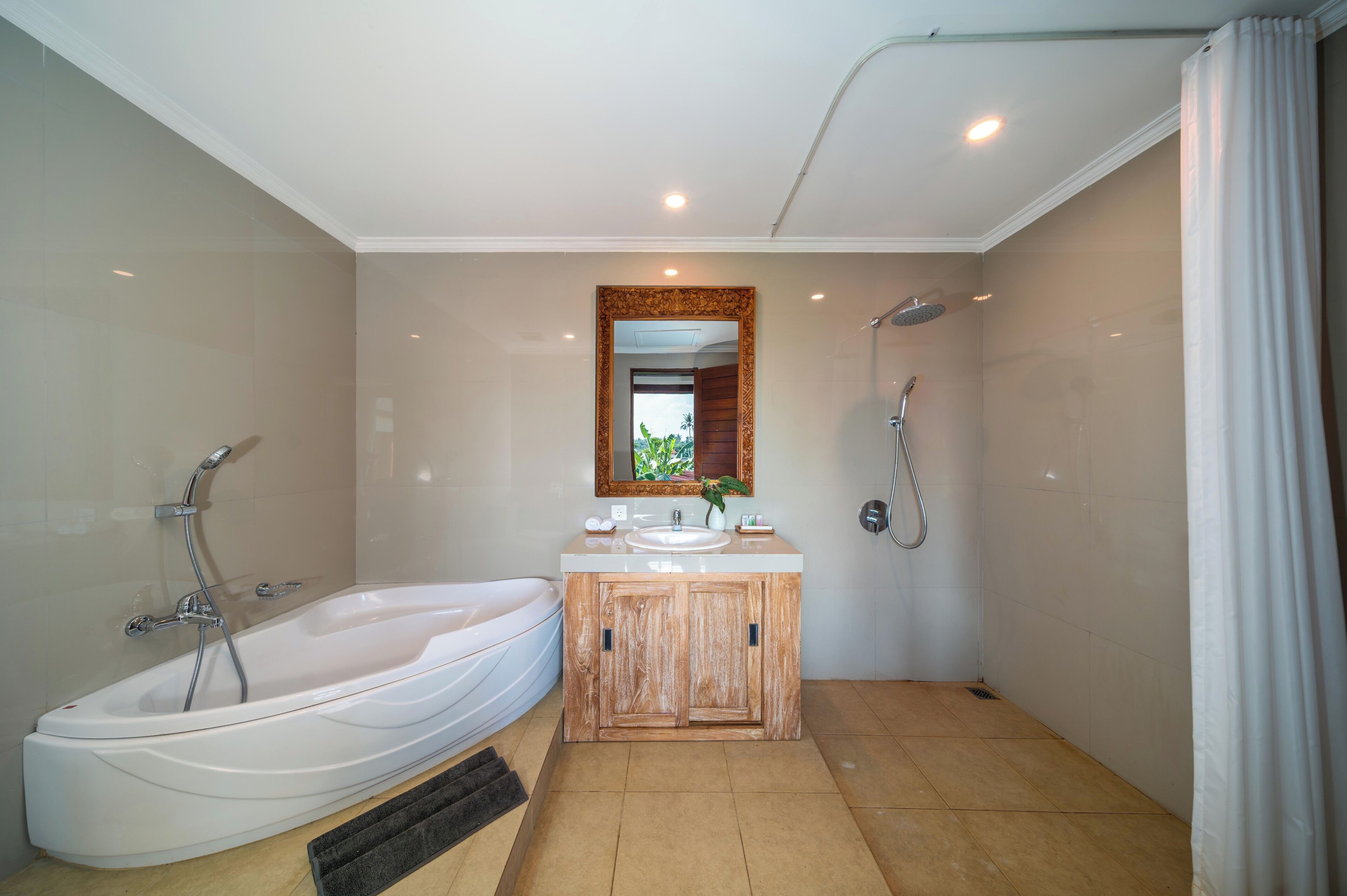 Ein modernes Badezimmer mit einer freistehenden Badewanne, einem Holzbadezimmermöbel, einem Spiegel und einer Dusche.