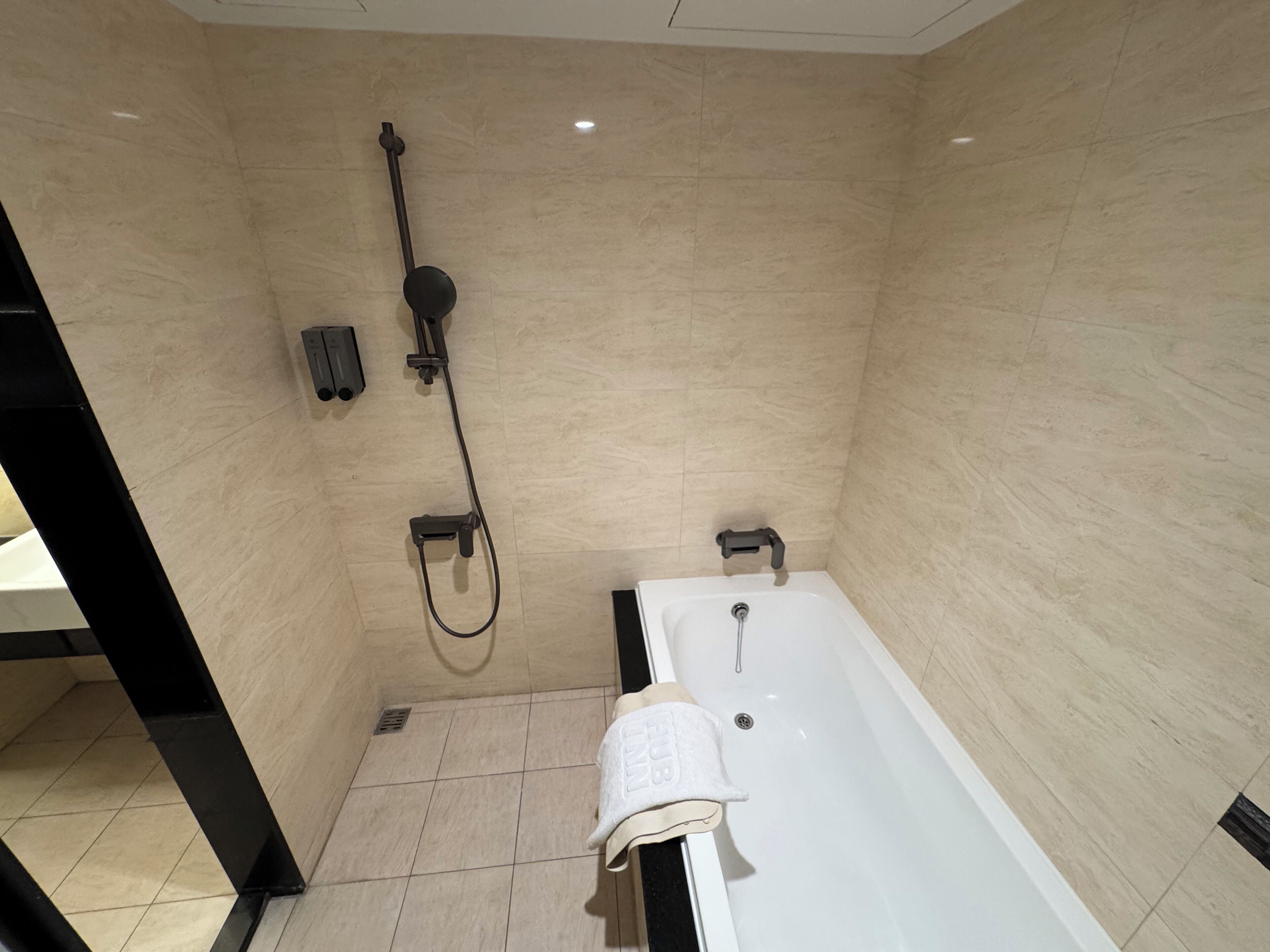 A modern bathroom with a bathtub, a shower, and a toilet.