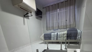 Ein Zimmer mit Etagenbett, Deckenventilator, einem fenster mit Vorhängen und Fliesenboden.