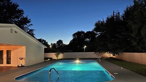 A rectangular swimming pool with a metal ladder, surrounded by a concrete deck. - Spacious Home with Heated Swimming Pool + Hot Tub + Event Room + SLEEPS 23 (Owensboro)