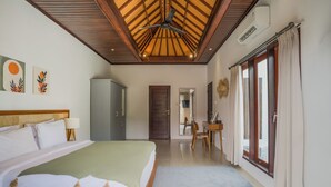 Ein Schlafzimmer mit Bett, Kleiderschrank, Schreibtisch und einem Fenster mit Vorhängen.