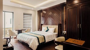 Habitación de hotel con una cama grande, un escritorio, una silla, un armario y vistas al exterior.