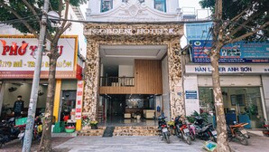 La entrada del Hotel Golden, con fachada de mármol, una escalera que lleva a la entrada y varias motocicletas estacionadas afuera.
