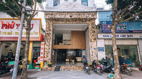 The entrance of the Golden Hotel with a marble facade, a staircase leading to the entrance, and several motorcycles parked outside. - Golden Hotel Ha Noi (Hanoi)