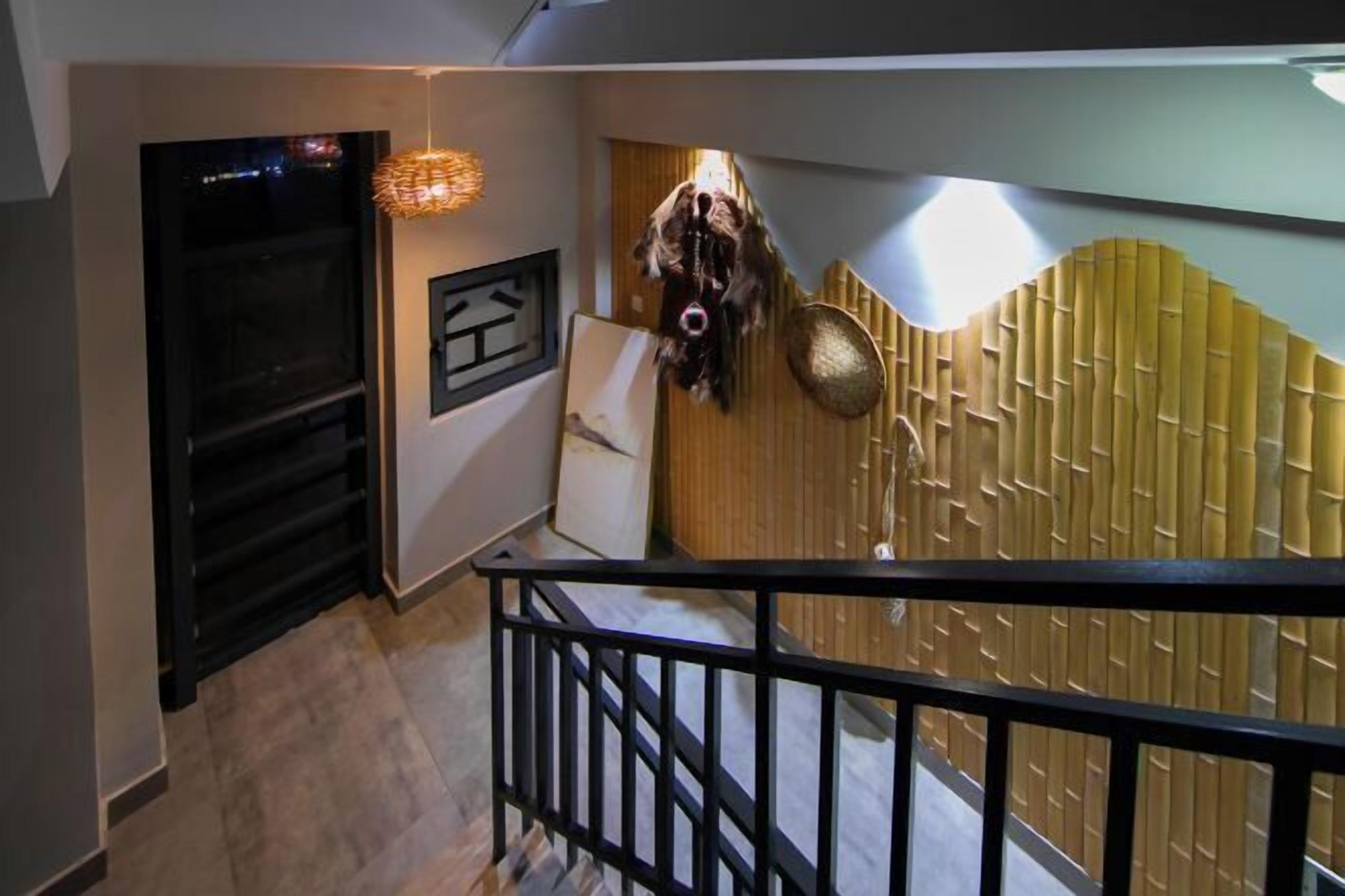 Ein modernes Interieur mit Treppe, Wanddekor und einer hängenden Maske.