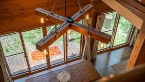 A wooden ceiling with hanging light fixtures and large windows.