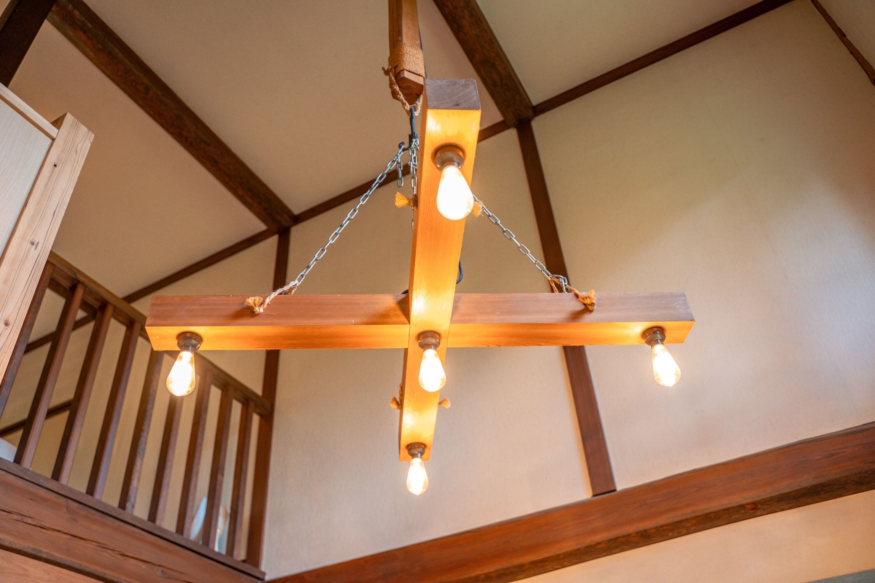 A wooden ceiling with exposed beams and four hanging light fixtures.