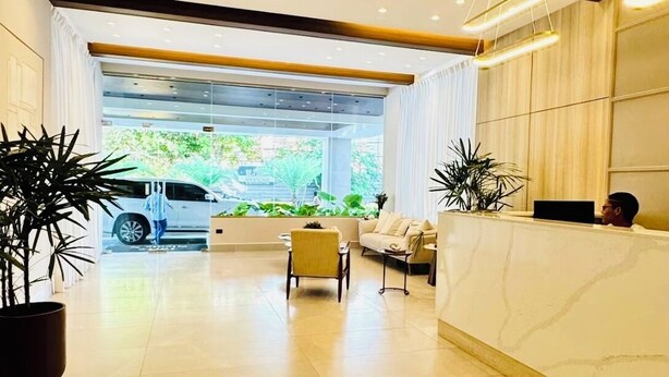 Eine geräumige Lobby mit Empfangstresen, einer Sitzecke und Blick auf den Parkplatz.