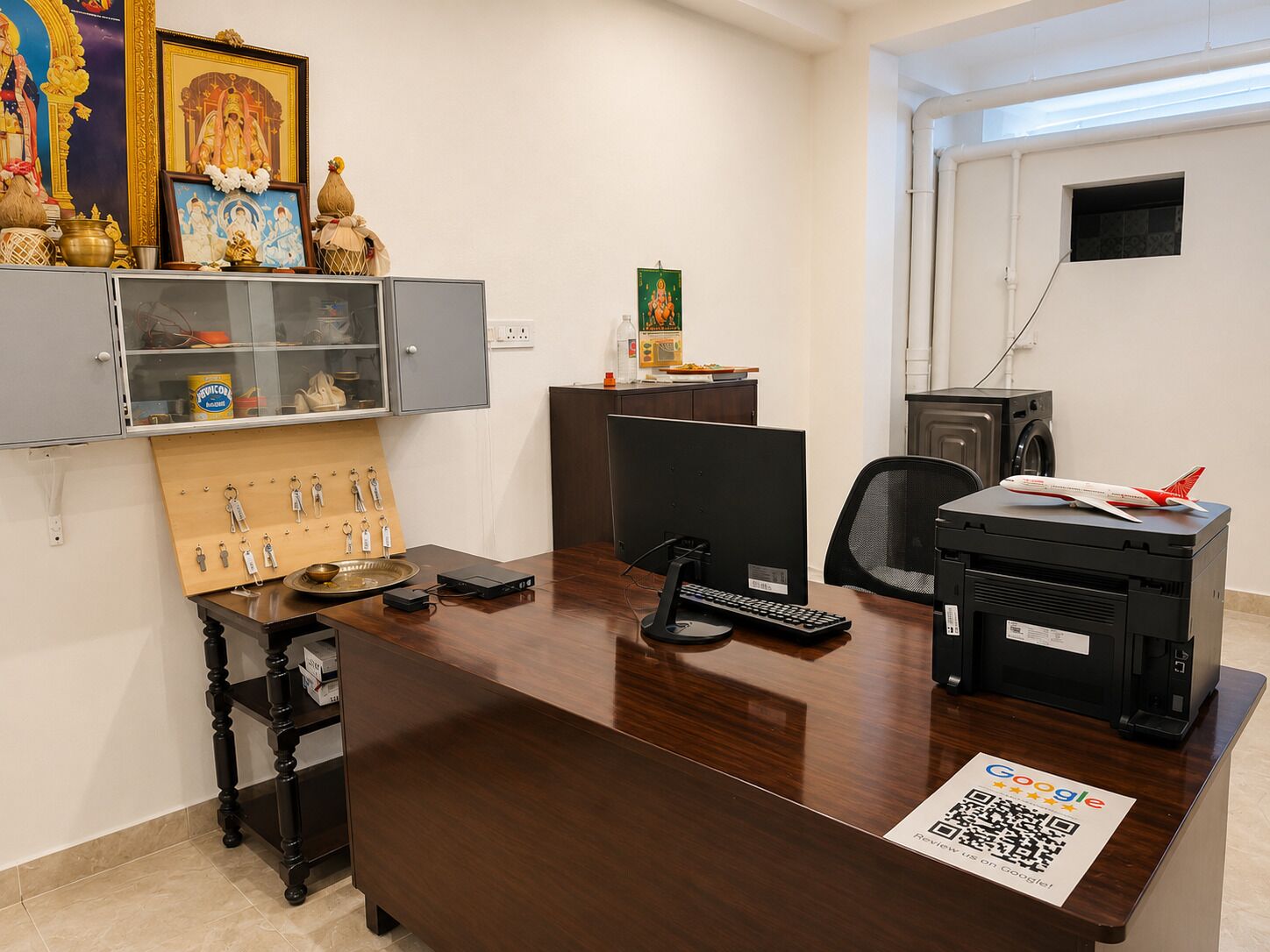 A modern office with a desk, computer, printer, and decorative items.