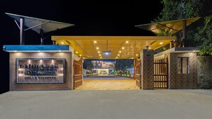 Een goed verlichte ingang met een bord waarop staat 'Natuurpaden' en 'By Thomas Cook Chilla Fishkesh'.