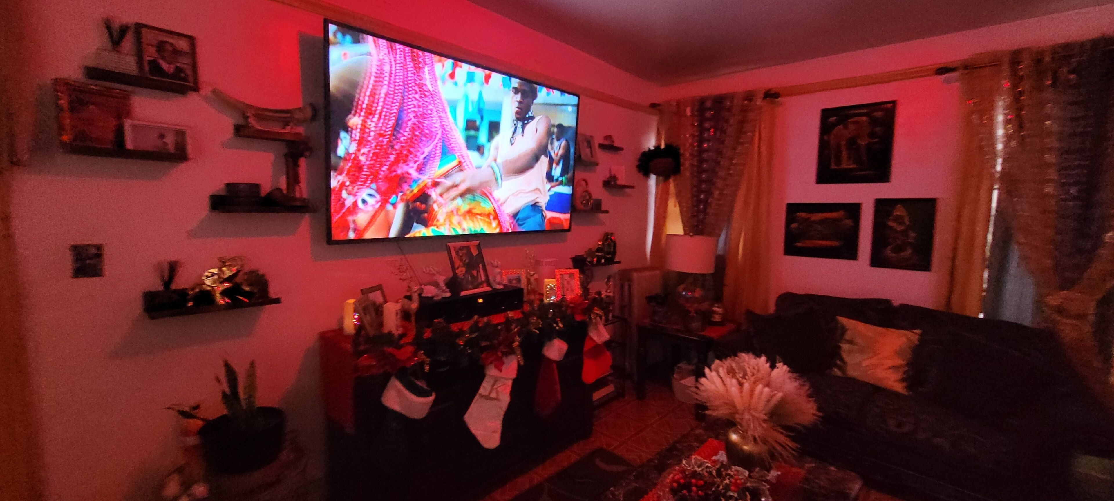 Un saló amb televisió plana penjada a la paret, un sofà, una taula de centre i diverses decoracions.