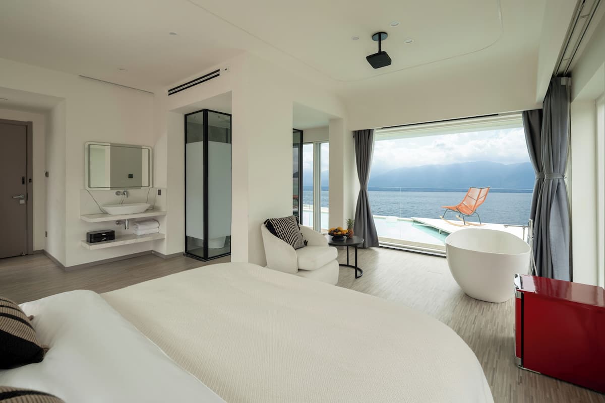 Quarto casal com design assinado, vista para o mar | Edredons de pluma, escrivaninha, cortinas blackout