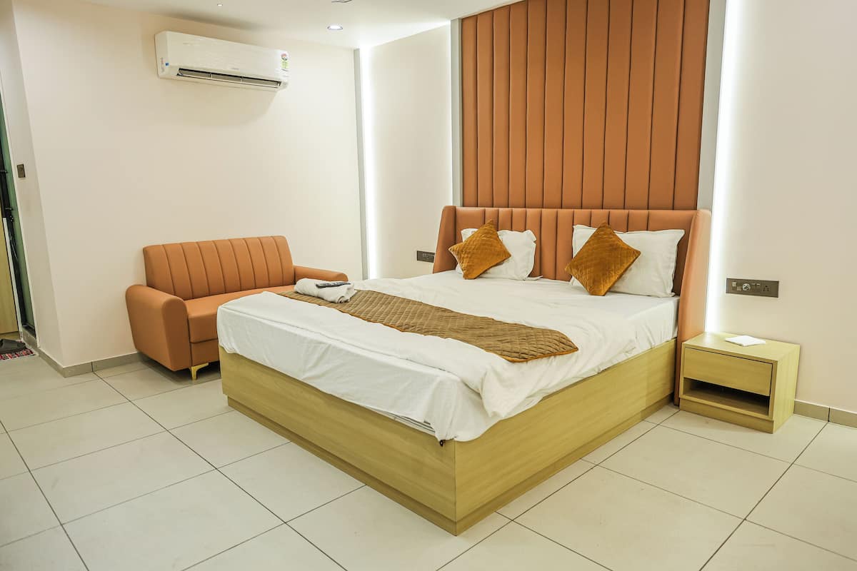 Une chambre à coucher moderne avec un lit en bois, un canapé marron et une table de chevet.