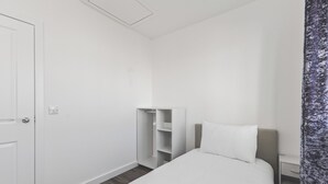 Ein Hotelzimmer mit einem Bett, einem Kleiderschrank und einem Nachttisch.