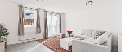 A modern living room with a sofa, coffee table, and a patterned rug.