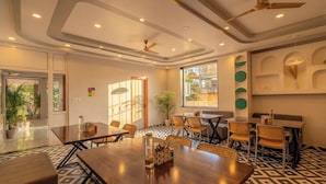 A conference room with a large table, chairs, ceiling fans, and a view of the outdoors.