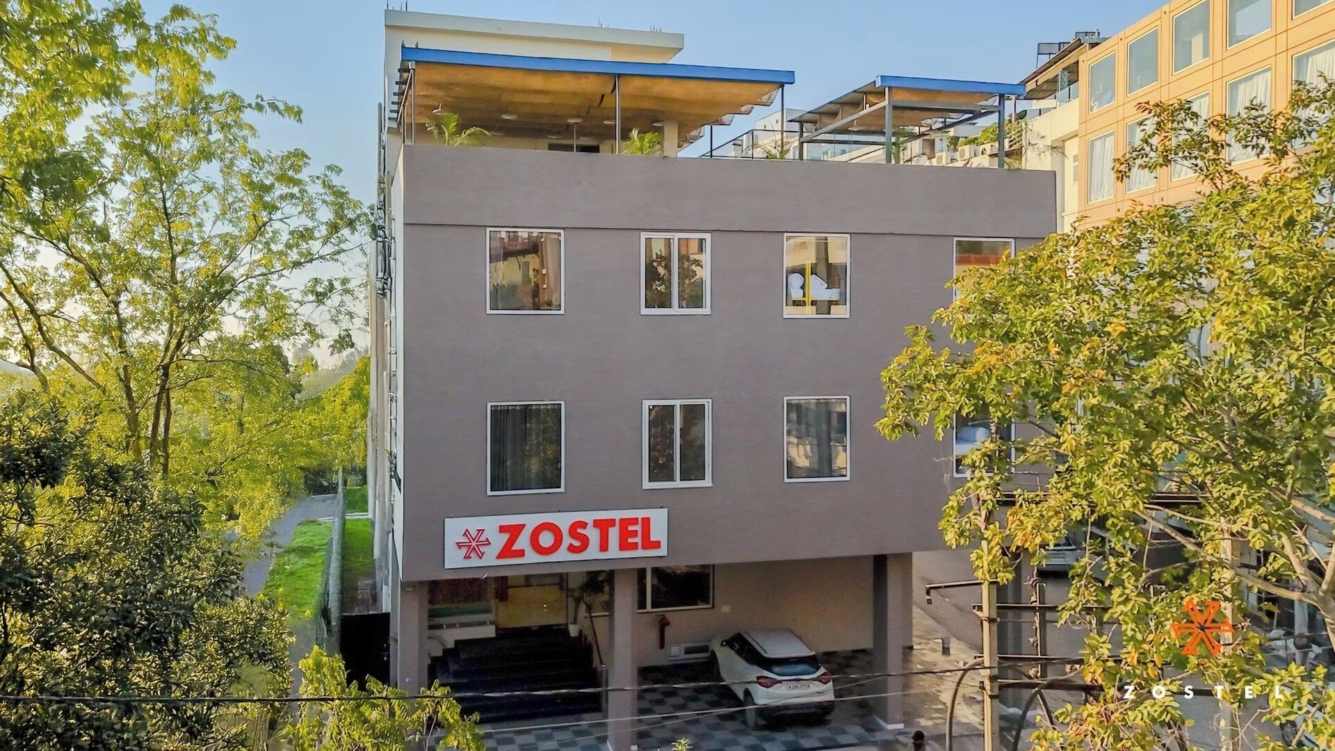 Un immeuble à plusieurs étages, sur lequel on peut lire l’inscription « ZOSTEL », ce qui indique qu’il s’agit d’une auberge de jeunesse.