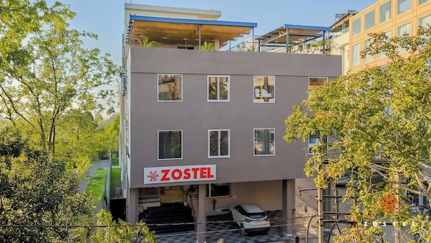 A multi-story building with a sign reading 'ZOSTEL' indicating it is a hostel.