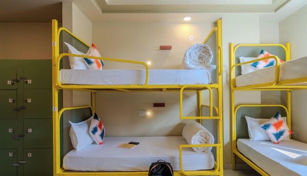A bunk bed room with a green storage unit and a single bed with a phone on it. - Zostel Jaipur (MI Road) (Jaipur)