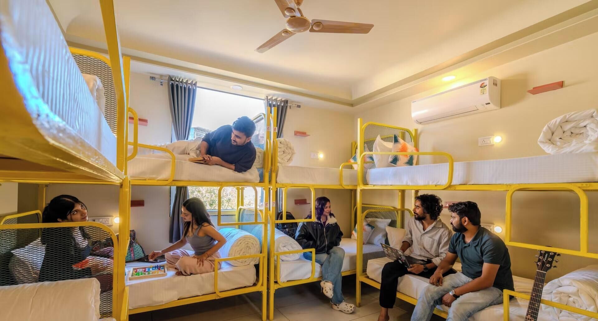 Un dormitorio con literas, ventilador de techo y aire acondicionado.