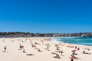 A crowded beach with people sunbathing and swimming. - Bondi Beach Breeze - Walk to Beach with Parking (Bondi Beach)