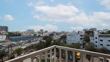 Un paisaje urbano con diversos edificios, una calle concurrida y cielo despejado.