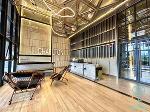 A modern interior with a reception desk, seating area, and a large window. - Millerz Square by Mana Mana (Kuala Lumpur)