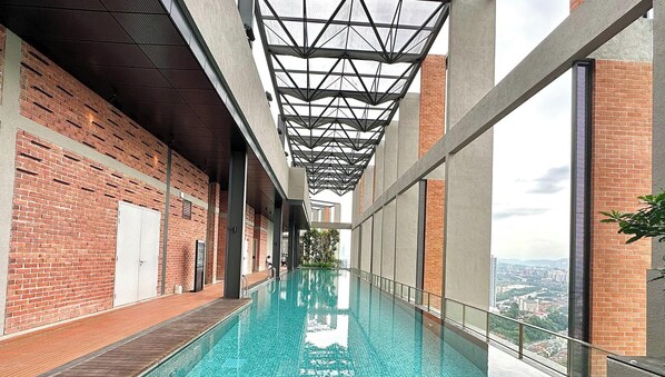 A long indoor swimming pool with a modern design, brick walls, and large windows offering city views. - Millerz Square by Mana Mana (Kuala Lumpur)