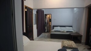 Un dormitorio con cama, mesita de noche, silla y puerta.