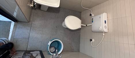 A bathroom with a sink, toilet, and bidet.