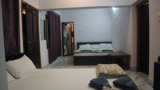 Un dormitorio con cama, un banco y una puerta que da a otra habitación.