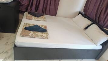 A bed with a dark frame, two pillows, and a blanket.
