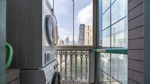 A laundry area with a view of a cityscape through a window. - Today Aparthotel (Shanghai)
