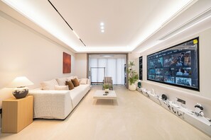 Apartamento Deluxe | Zona de estar | Smart TV de 100 pulgadas con canales digitales