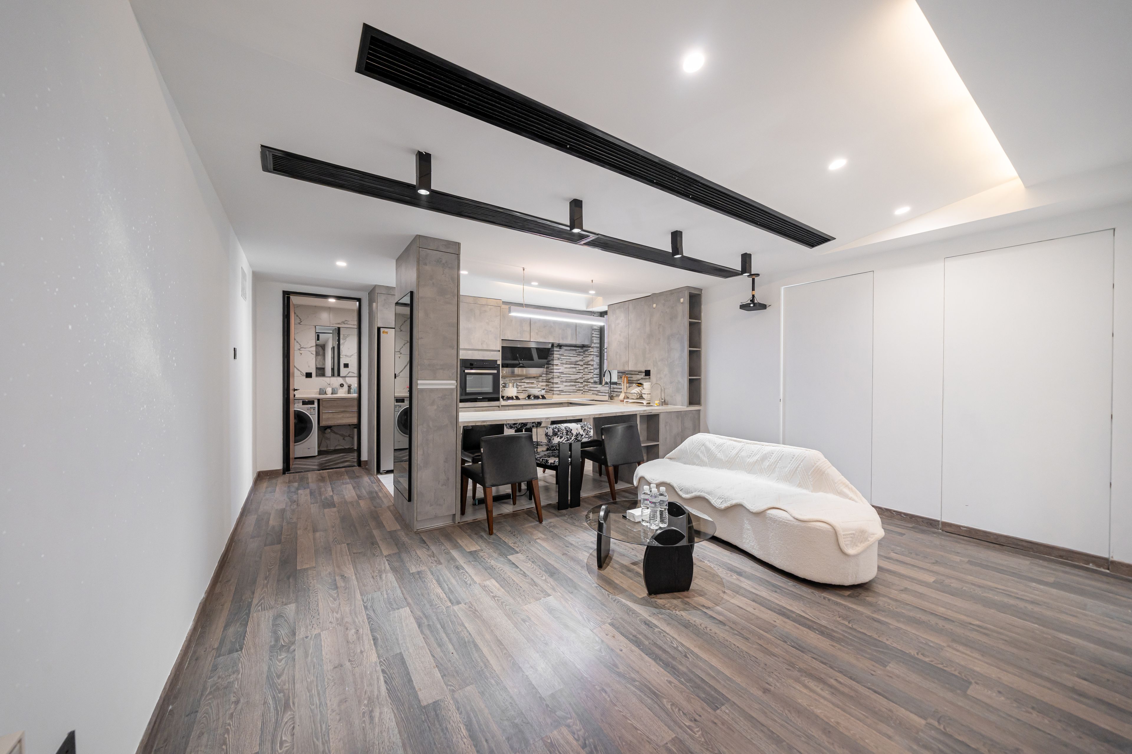 A modern interior with a kitchen, dining area, and a cozy seating space.