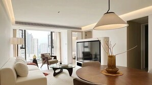 A modern living room with a sofa, coffee table, dining table, and a TV. - Today Aparthotel (Shanghai)