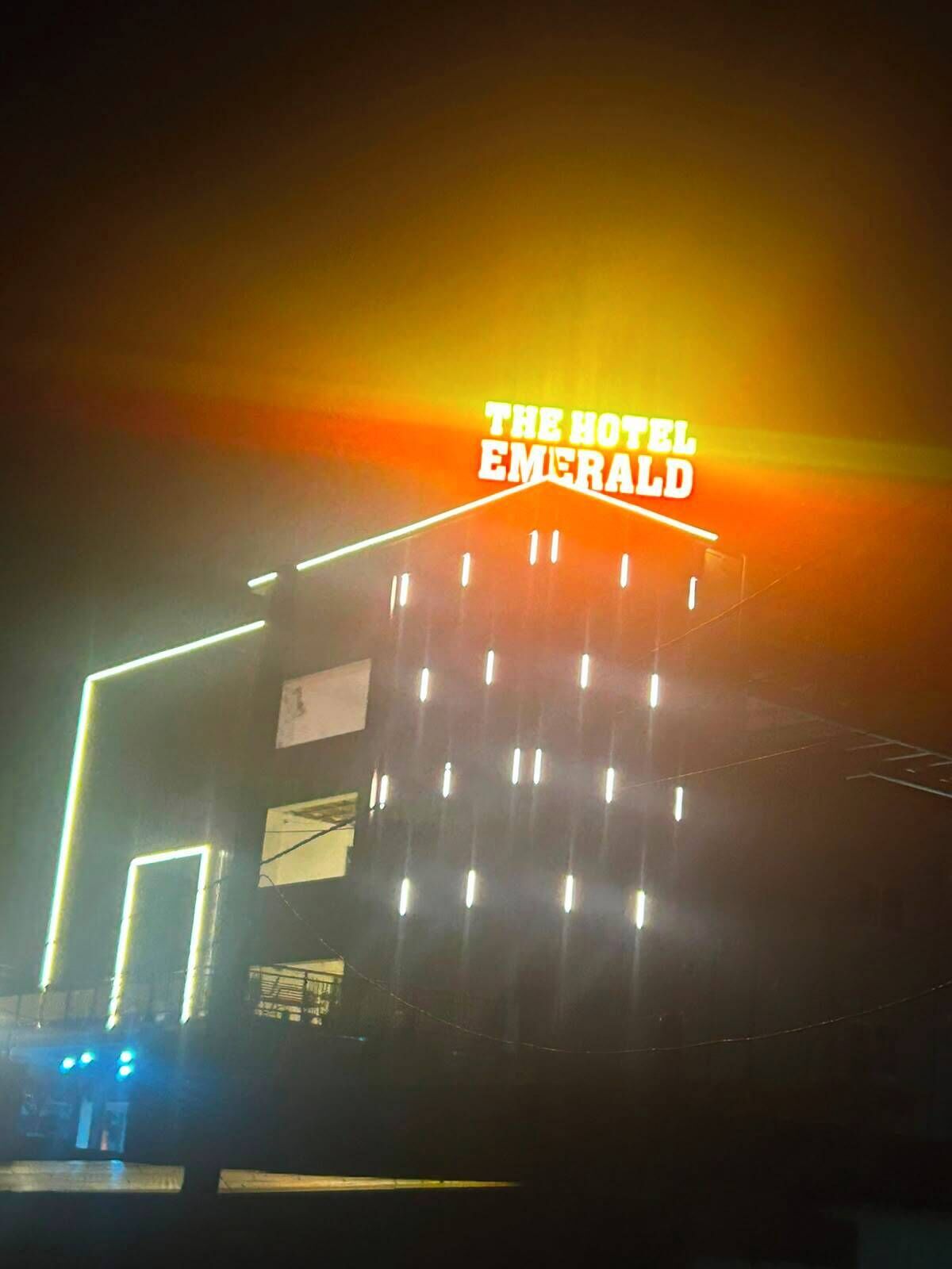 Un edificio con un cartel que dice 'The Hotel Emerald' de noche.