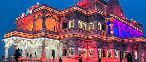 Un templo con intrincados grabados y varios niveles, iluminado por luces vibrantes.