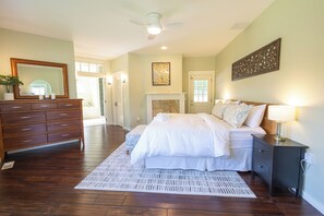 A bedroom with a bed, dresser, mirror, and a fireplace. - The Tyrolean: Pool, Hot Tub & Ski Hill Charm (Leavenworth)