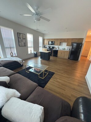 A modern living room with a sofa, a coffee table, and a ceiling fan. - 2bed2bath Apartment Located In Downtown Baltimor Area Nice & Cozy (Baltimore)
