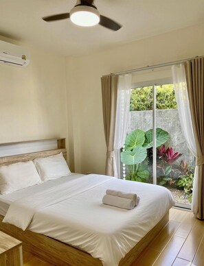 A bedroom with a bed, a ceiling fan, and a window with curtains. - HOUSE NO.89 (Chiang Mai)