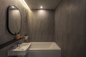 Deluxe tweepersoonskamer | Badkamer | Een haardroger, handdoeken, zeep, shampoo