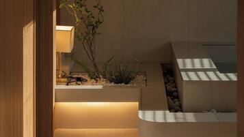 Ein modernes Interieur mit Holztür, beleuchteter Lampe, Pflanze und integriertem Sitzplatz.