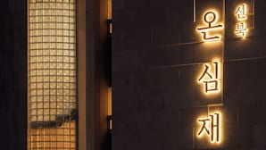 A building with a large illuminated sign in Korean characters. - ONSHIMJAE (Pocheon)