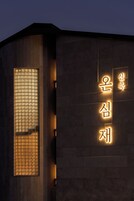 A building with a large illuminated sign in Korean characters.
