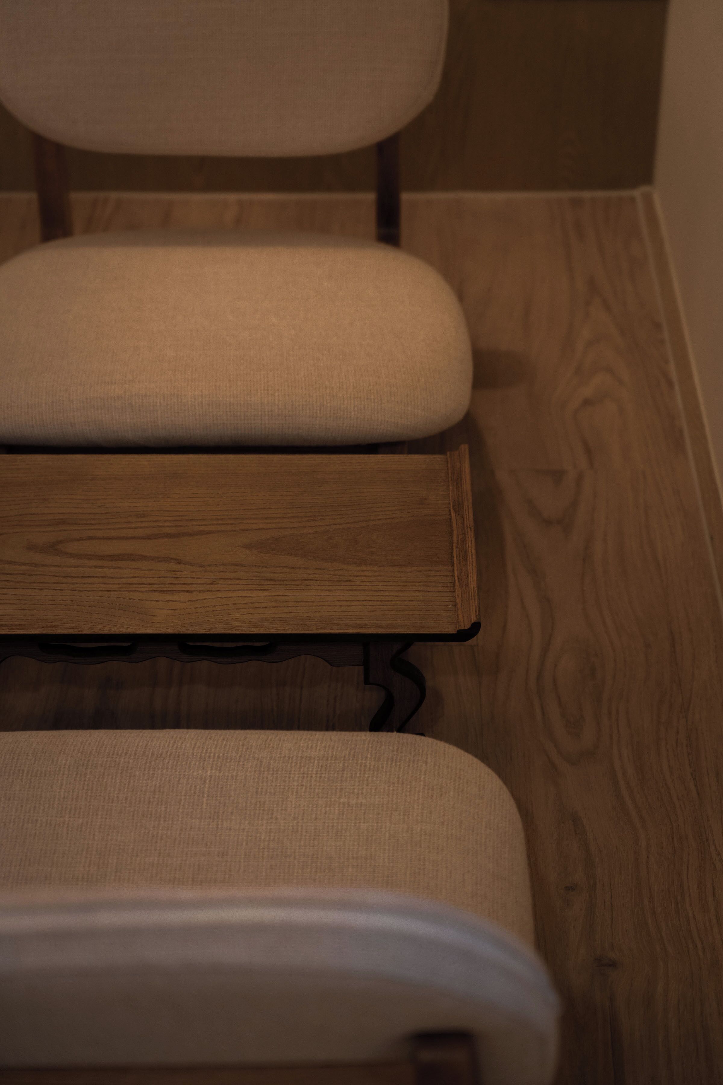 A wooden bench with a cushioned seat and backrest.