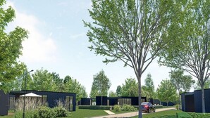 A modern outdoor area with a paved walkway, a car, and several buildings with dark exteriors. - Countryside Home by Palette Resort De-steppe (Ulicoten)