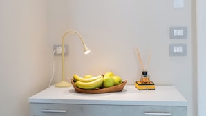Un escritorio con una lámpara, un frutero y un difusor.